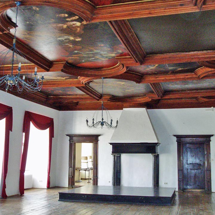 Blick in den großen Ahnensaal mit Deckengemälden und dunklem Holzboden