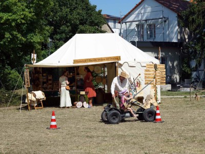Zwei Personen in mittelalterlicher Kleidung stehen vor einem Zelt.